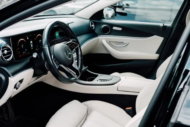 Cream leather rear seats inside a Mercedes-Benz E-Class used for airport pickups