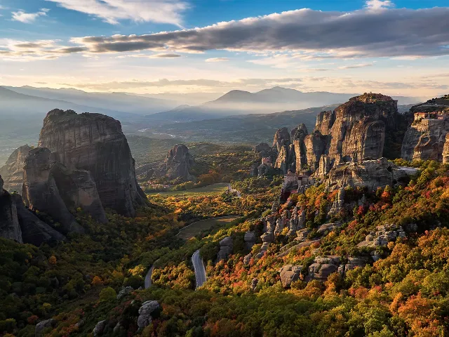 Autumn valley and winding road between the giant rocks of Meteora