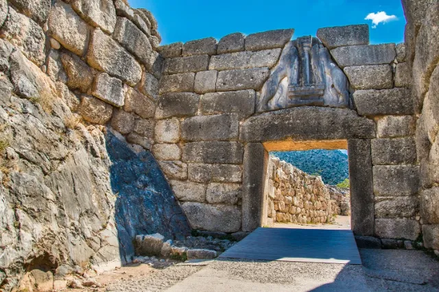 The Lion Gate in the stone walls of ancient Mycenae under a blue sky